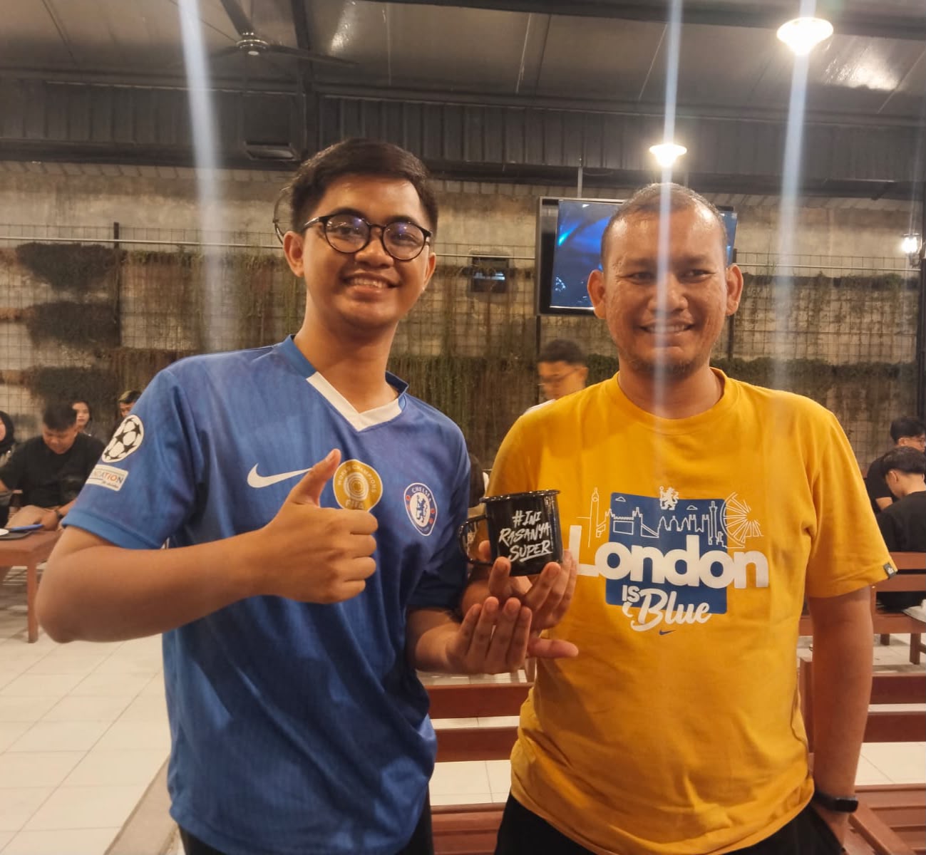 Peserta nobar Kopinan 24 menunjukkan mug doorprize dari Djarum.