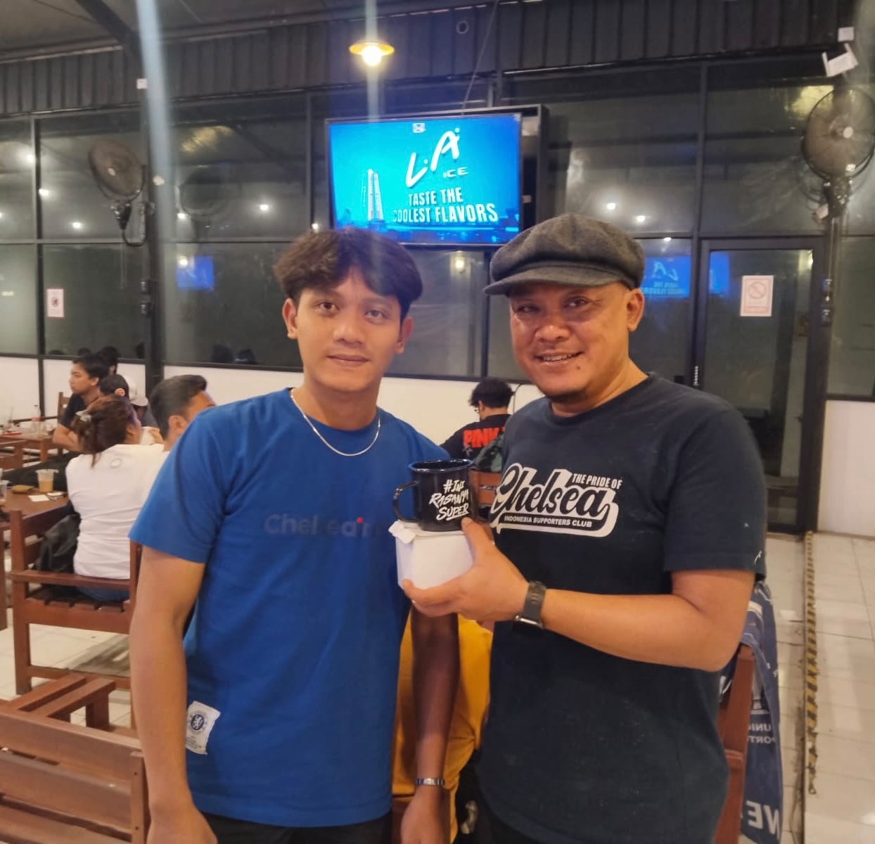 Peserta nobar menunjukkan mug dan bingkisan dari sponsor.