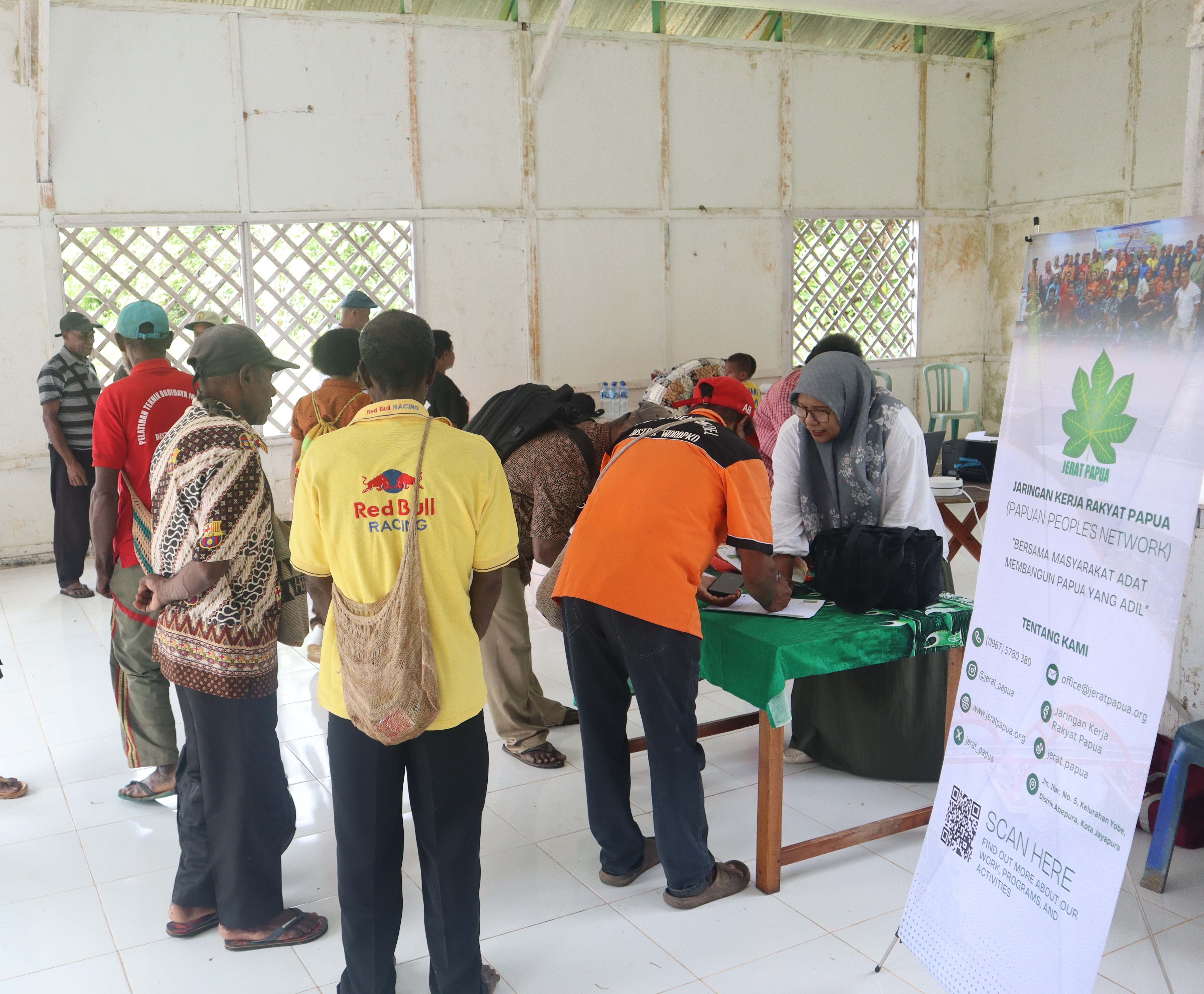Peserta kegiatan Revitalisasi Kelembagaan Adat dan Penyusunan SOP Suku Muyu Kati melakukan registrasi sebelum mengikuti rangkaian kegiatan.