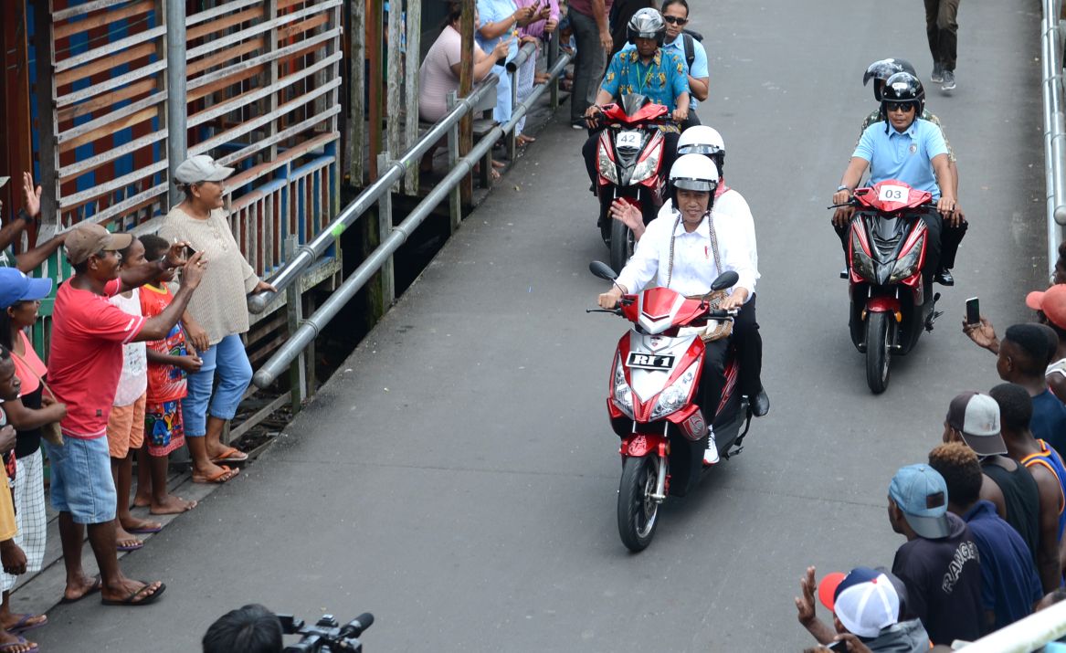 Presiden Jokowi dan Ibu Iriana Berboncengan Naik Motor Listrik di Asmat