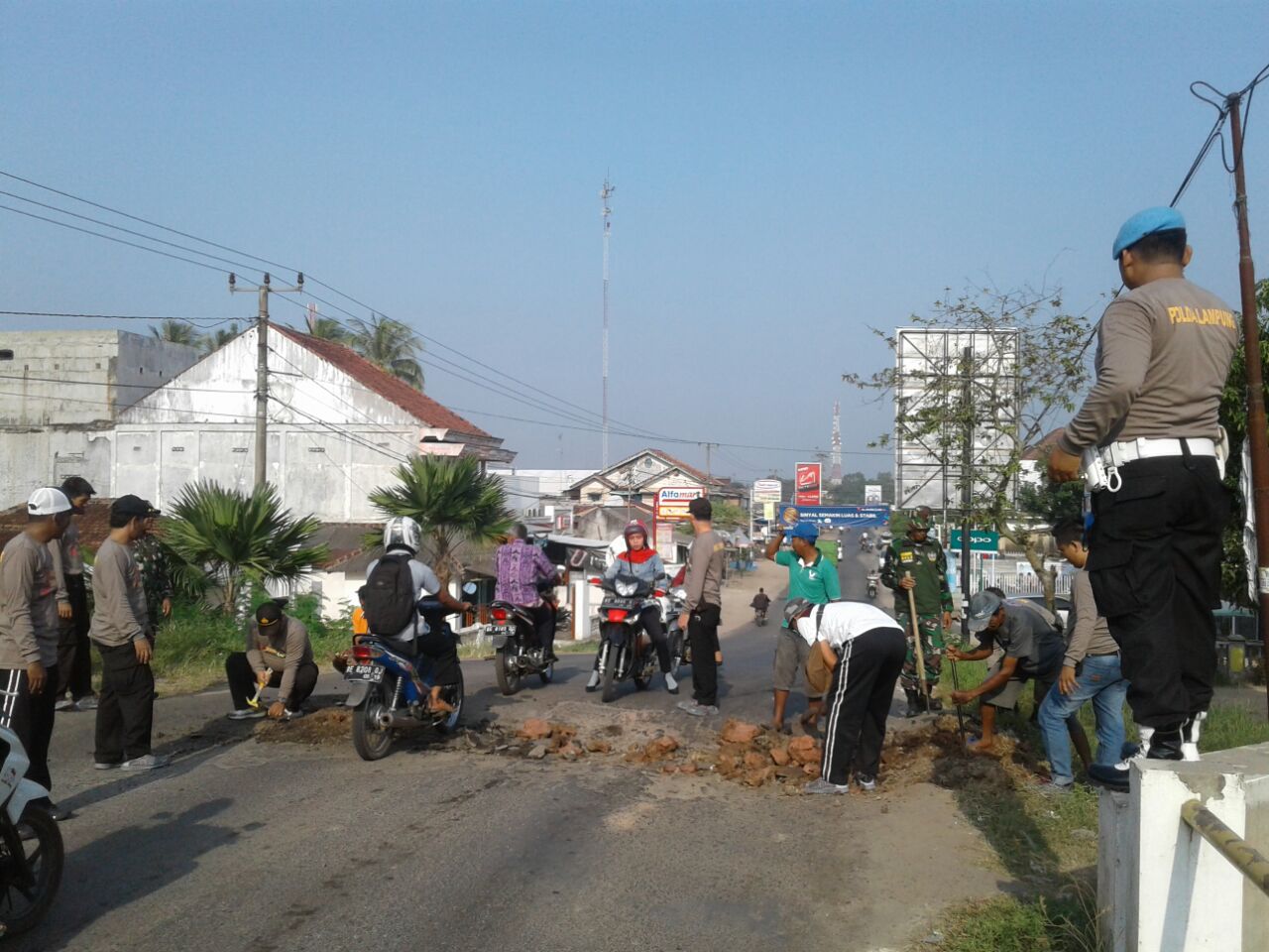 Polsek Dan Koramil Tumijajar Lakukan Jumat Bersih Timbun Jalan Rusak