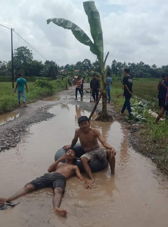 Protes Belasan Tahun Tak Diperbaiki, Warga Mandi dan Tanam Pisang di Kubangan Jalan